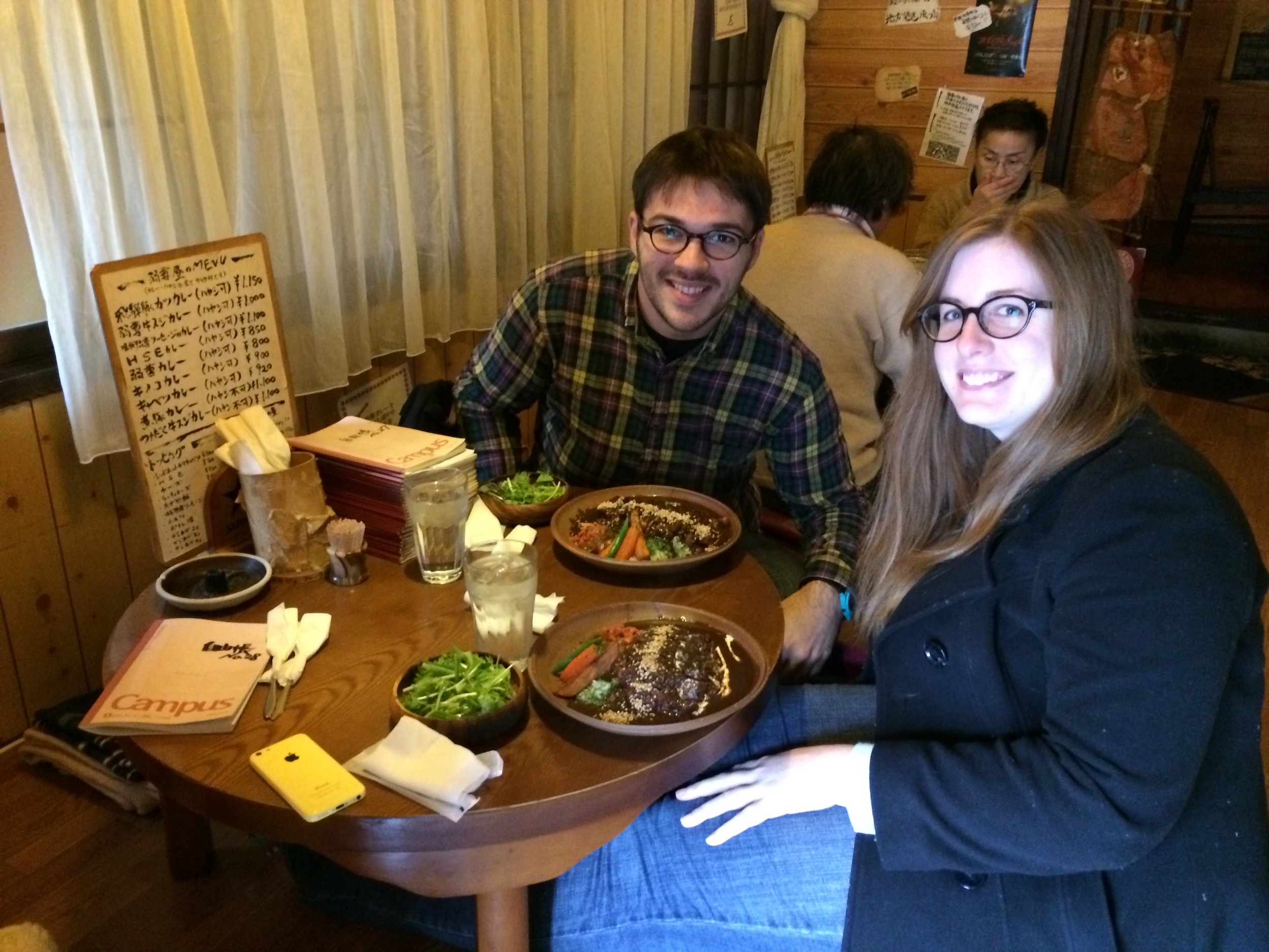 A woman (Erin) and a man (Ryan) sitting at a table after having been served Japanese curry in Takayama, Japan.